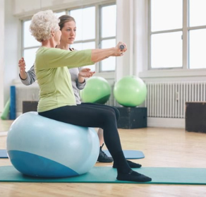 Woman Standing on Balance Board with Therapist